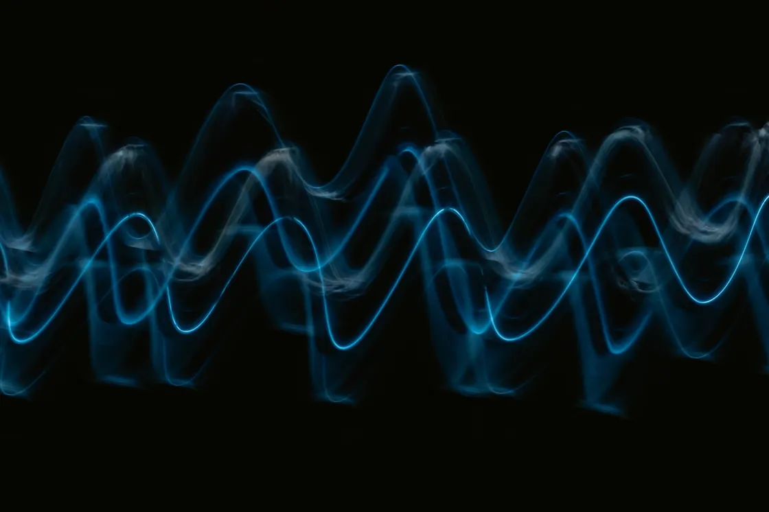 Two overlapping glowing wave patterns moving at different speeds, representing two different brain wave frequencies